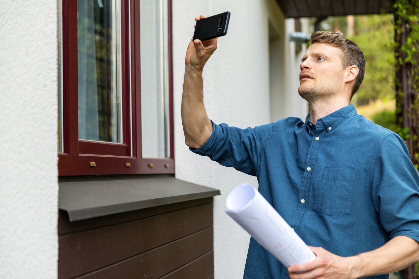 real estate appraiser taking pictures of property with phone